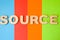 Word Source of large wooden letters on colored background of 4 colors: blue, orange, red and green. Use of word Source online, in