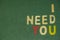 The word spelling to `I need you` on green background