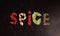 Word Spice made from spicy background with assortment of different hot chilies, allspice, brazilian peppers.