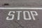 Word Stop written on an asphalt road, Stop Sign