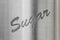 The word sugar on a metal background