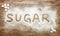 Word sugar and sugar cubes on wooden surface, high sugar level a