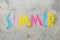 Word summer of paper multicolored letters on a light concrete background. summer. vacation. relaxation. top view