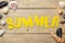 Word summer of paper yellow letters and seashells on a natural wooden background. summer. vacation. relaxation. top view