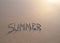 Word summer written in the sand