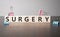 The word surgery written on wood cubes. Business and finance concept