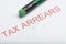 Word `Tax Arrears` with Worn Pencil Eraser and Shavings