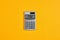 The word tax on calculator display with yellow background. Tax calculation, business finance