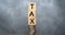 Word TAX written on wooden cubes on stacked coins on dark background. pay taxes concept - wooden blocks on coin stacks