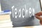 The word Teacher hand written on a blackboard.