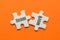 The word Team Work on two matching puzzle on orange background
