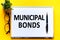 Word text MUNICIPAL BONDS on white paper card, business concept