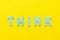 Word THINK made out of small blue letter on yellow background,