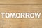 Word tomorrow on a wooden board