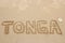 Word Tonga written in a sand
