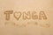 Word `Tonga` written in a sand