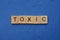 Word toxic made from brown wooden letters
