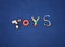 Word TOYS made from different toys on blue textile background. C