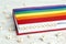 Word Transgender written in wooden blocks in red notebook with rainbow LGBT flag on wooden table