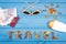 Word travel with shape of sun, sunglasses, sun lotion, passport with currencies euro