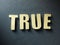 The word True on paper background