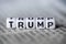 Word TRUMP formed by wood alphabet blocks on newspaper