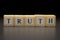 The word TRUTH written on wooden cubes, isolated on a black background