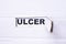 The word ulcer is written on white paper . Medical concept