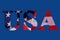 Word USA with american flag under it on blue background. American symbol celebrating holiday USA. Banner national flag colors