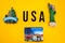 Word USA with magnets from new york and san francisco on yellow background, travel destination