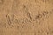 Word Vacation written in the sand on the beach.  Summer travel concept. Birds footprints on yellow sand