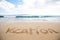 The word vacation written in sand at a tropical island beach