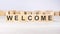 word WELCOME inscribed on wooden cubes lying on a light table. economy and investments concept.