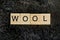 The word from wooden letters lies on a black gray fur