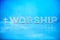 Word Worship made with cement letters on blue marble background. Copy space. Biblical, spiritual or christian reminder