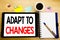 Word, writing Adapt To Changes. Business concept for Adaptation New Future Written on tablet laptop, wooden background with sticky