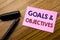 Word, writing Goals Objectives. Business concept for Plan Success Vision Written on sticky note red paper, wooden background with