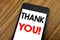 Word, writing handwriting Thank You. Business concept for Thanks Message Written on mobile phone cellphone, wooden background with