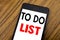 Word, writing handwriting To Do List. Business concept for Plan Lists Remider Written on mobile phone cellphone, wooden background