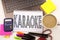 Word writing Karaoke in the office with laptop, marker, pen, stationery, coffee. Business concept for Singing Karaoke Music Worksh
