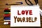 Word, writing Love Yourself. Business concept for Positive Slogan For You Written on notebook, wooden background with office equip