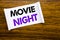 Word, writing Movie Night. Business concept for Wathing Movies written on sticky note paper on the wooden wood structure visible