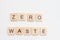 Word ZERO WASTE made from wooden cubes on white. Eco-friendly concept. Selective focus