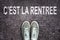 Words C`est la rentree meaning back to school written on asphalt road with sneakers shoes, high school and college con