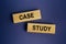 The words `CASE STUDY` is written on a wooden blocks on a dark blue background.