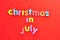 The words christmas in July on a red background