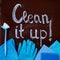 The words `clean it up!`on the chalkboard and spring cleaning kit