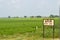 Words Darauli written on Milestone marker of Indian railway train station directional sign board on rural agriculture field