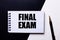 The words FINAL EXAM written in red on a black and white background near the pen