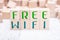 The Words Free Wifi Formed By Wooden Blocks On A White Table